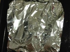 羊排放在锡纸上，撒上迷迭香，四周包裹严实放入烤盘中