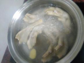 锅内冷水放入鸭掌，姜片，水开捞出，用冷水冲洗