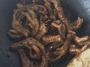放入鸭掌翻炒，放入白糖，生抽老抽和料酒，给鸭掌上色