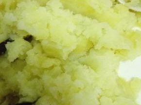 蒸好的土豆用勺子压成土豆泥