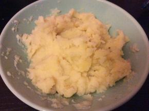捞出后的土豆去皮，按压成泥状，加少许的盐和黑胡椒调味，搅匀备用