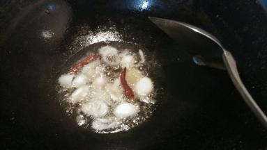 锅内放少量的油加热，放入姜片葱段干辣椒爆香