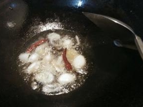 锅内放少量的油加热，放入姜片葱段干辣椒爆香