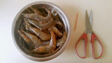 剪开背部的虾壳，用牙签挑去虾线