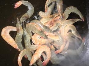 锅内放多一点的油，油温七分热的时候放入大虾，翻炒至双面变色，期间可以用铲子将大虾的虾油压出来