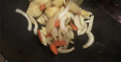 锅内留底油放入洋葱煸炒出香味，倒入炸好的蟹块和胡萝卜土豆翻炒