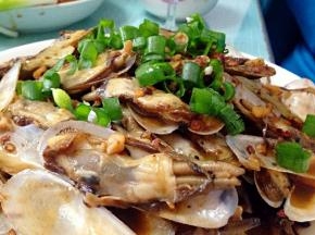把焯好的蛏子倒入锅中翻炒，放上适量老干妈炒香，滴入少许生抽，快速炒匀后出锅