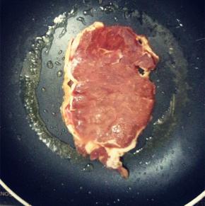 放入牛排，一面煎至金黄翻至另一面，撒上少量的海盐和黑胡椒