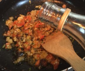 倒入蟹黄和蟹膏，放料酒，用铲子压碎