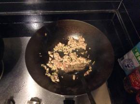 利用锅中剩余的油炒葱姜蒜末，爆香后倒入豆瓣酱和肉末一起炒