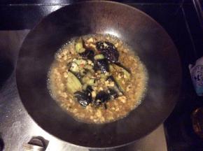 肉炒熟后加水，淋上适量酱油、盐和少许白糖调味，倒上炸好的茄子，加盖焖煮2-3分钟，汤汁浓稠收汁出锅