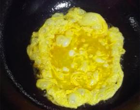 锅中倒油，加热后调小火，蛋液入锅煎炒