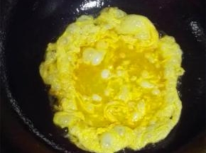 锅中倒油，加热后调小火，蛋液入锅煎炒