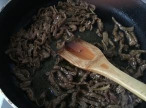 热锅冷油，放入腌制好的牛柳滑散，炒至牛肉变色