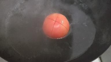 锅内加水煮沸，将西红柿放入沸水中煮5分钟