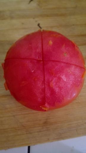 将煮好的西红柿取出，剥开表面的果皮