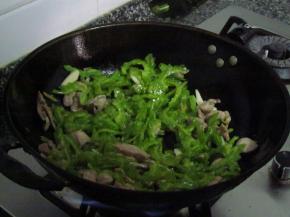 瘦肉丝入油锅翻炒，炒至6成熟倒入苦瓜混炒，苦瓜断生，放入盐、鸡精进行调味