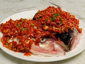 在腌好的鱼头上摆上切好的姜丝，表面再铺上一层红剁椒
