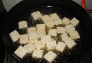 锅中倒油烧热，再放入豆腐片煎至两面金黄之后盛出