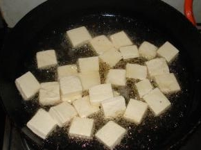 锅中倒油烧热，再放入豆腐片煎至两面金黄之后盛出