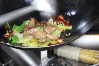 然后将腌好的牛肉和预先备好的酸菜倒入锅中，继续翻炒