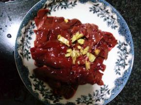 猪肝用盐水泡30分钟去除血水，用清水洗好后切片，放上生姜粒腌一会去腥