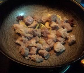 放入牛肉块，倒入料酒和生抽老抽，翻炒均匀