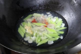 往锅中倒水，待其烧开后，放入西芹，百合以及虾仁焯熟。