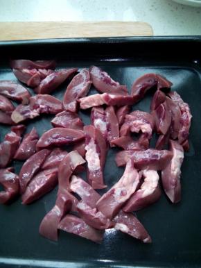 猪腰洗净，在腰筋切成两片，分别用刀划几道不要断开，然后切成月牙片，洗净后沥干水放入烤盘