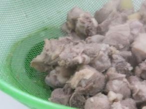 将鸭块捞出，去除葱姜蒜，用温水冲洗鸭块表面的浮沫，沥干水分