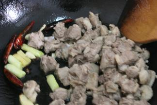 倒入鸭块，中火煸炒出鸭肉，炒至鸭块的表皮微微泛白，调成小火将鸭油全部煸炒出来