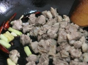 倒入鸭块，中火煸炒出鸭肉，炒至鸭块的表皮微微泛白，调成小火将鸭油全部煸炒出来