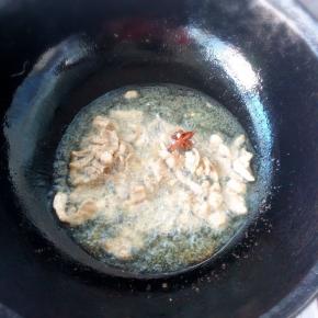 热锅凉油，倒入大蒜八角炒肉，将五花肉的香味炒出来