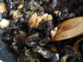 放入肉片翻炒，炒至肉片变色加入木耳和生抽，翻炒均匀