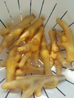 锅中加清水、白醋、糖和鸡爪，大火烧开后煮十分钟左右，捞出风干水分