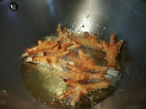 起锅倒油，把鸡爪放入锅中大火炸，微熟后转中火，炸的水分差不多干了