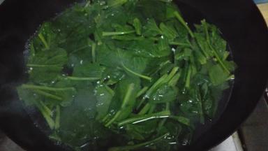 将切好的菠菜放入沸水中焯水，捞出沥干