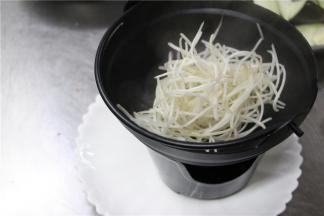 捞起焯熟的豆芽，将豆芽码在砂锅当中