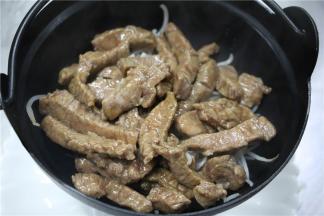 然后捞起焯熟的牛柳，铺在豆芽上面