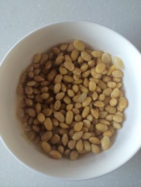黄豆事先用清水泡发，捞出沥干倒入锅中炒干，放到腌好的猪蹄里