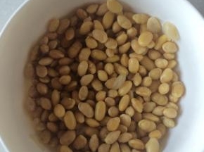 黄豆事先用清水泡发，捞出沥干倒入锅中炒干，放到腌好的猪蹄里