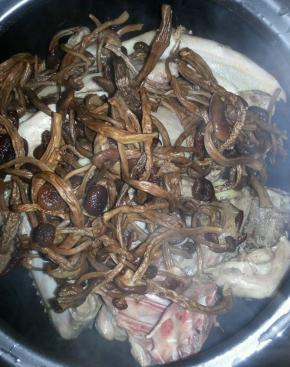 鸭块放在锅的底部，上面盖上茶树菇和枸杞，倒入2勺料酒大火煮开