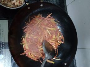 锅中剩油，把胡萝卜丝放入锅中翻炒