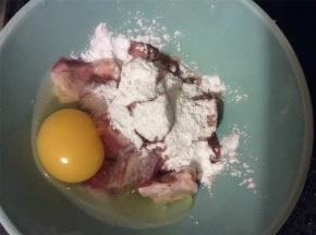 在腌好的五花肉中打入一颗鸡蛋，加入适量的淀粉，搅拌成糊，使每块五花肉表面都均匀的覆盖上一层蛋糊