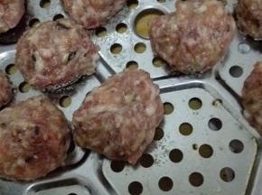 戴上1次性手套，将肉馅握在手中，让肉馅从虎口中挤成肉丸