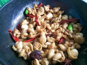 肥肠加料酒、姜片和大料煮20分钟，出锅捞起切段。锅中加油，五成热放入肥肠中火炒两分钟，加入豆瓣酱、料酒、干辣椒、青椒等调料，中火煸炒五分钟