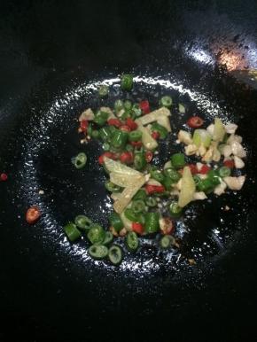 锅里另起油，爆香姜片、蒜末，加入红辣椒和青辣椒