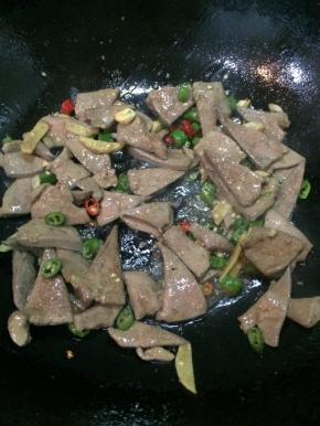 加入断生的猪肝，加酱油、糖、米酒、适量十三香和老干妈提香