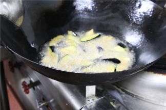 锅中放油，待其8分熟时，放入茄子块将其炸酥