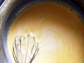 把蛋挞液放于一旁晾凉，加入打散的蛋黄，并且不停的搅拌均匀